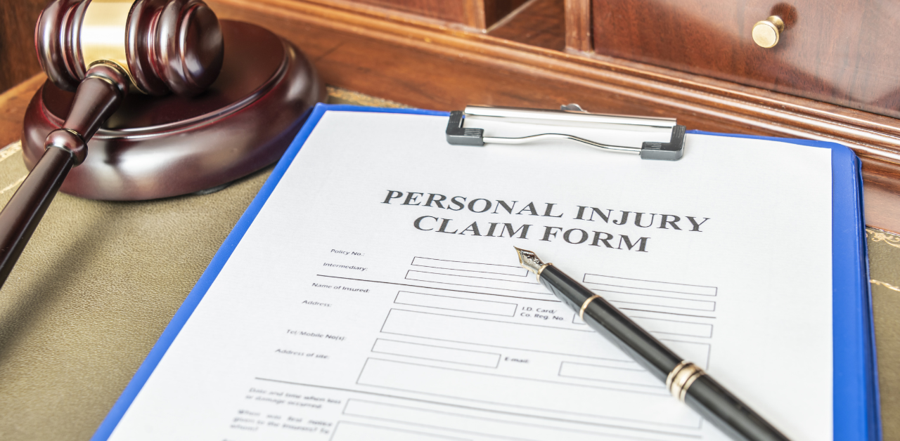 Personal injury claim form with pen and gavel on desk, representing legal case documentation and filing