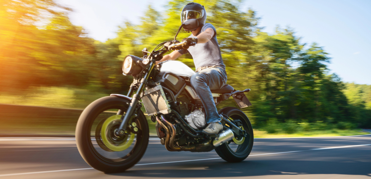 Man riding a white motorcycle on the highway and wearing a white helmet