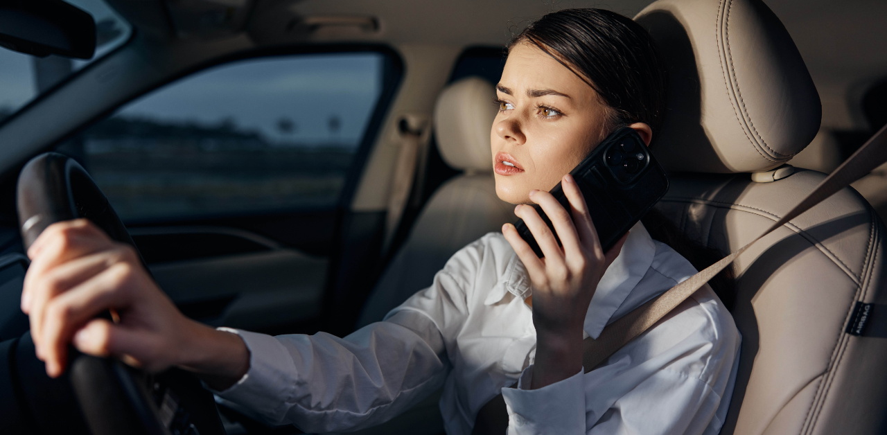 Woman talking on phone while driving at night, unsafe driving behavior