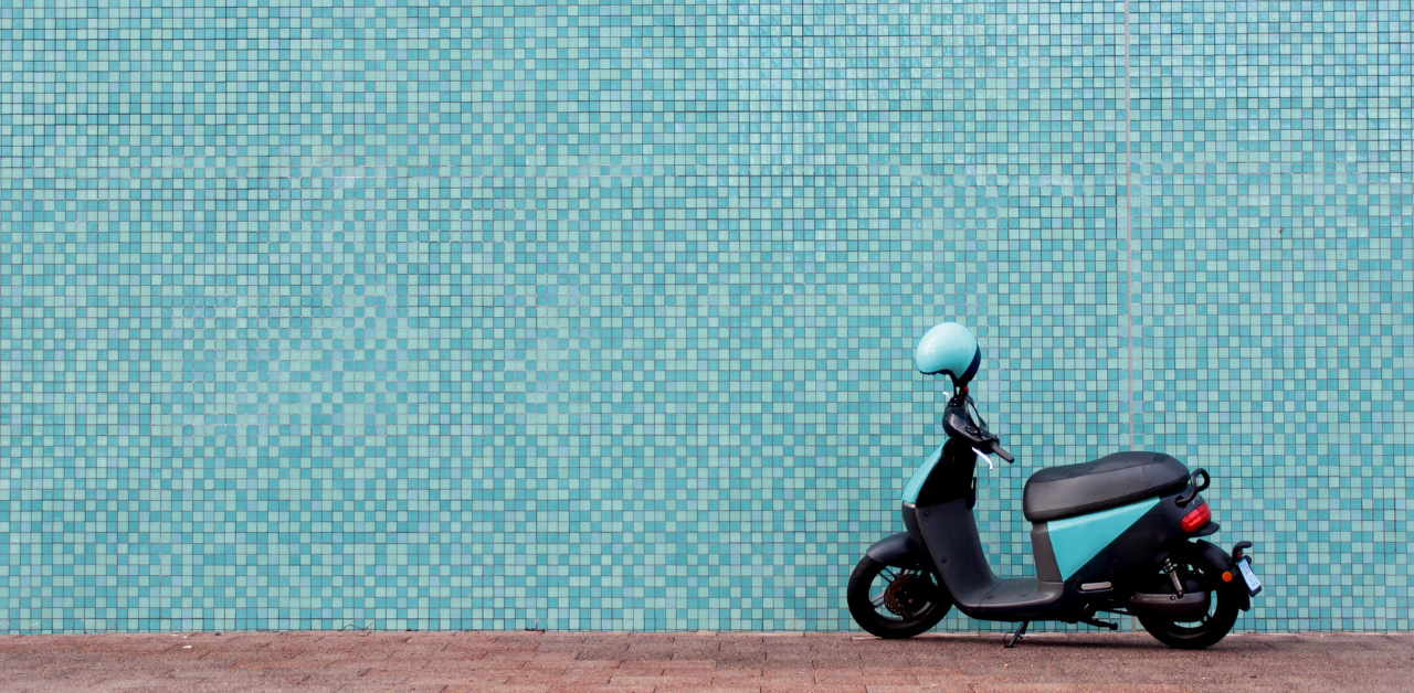 Parked scooter against turquoise wall, urban scene linked to Casino Escalator Accident Claims travel context