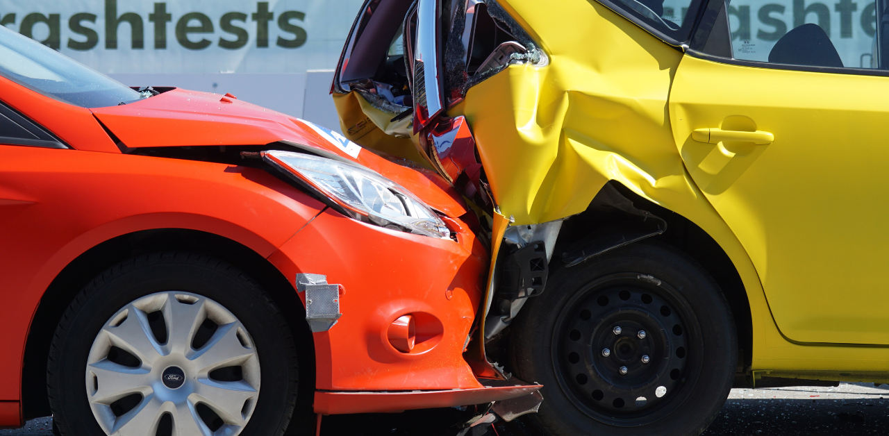 Crashed red and yellow cars in rear-end collision, showing accident impact on pedestrian safety