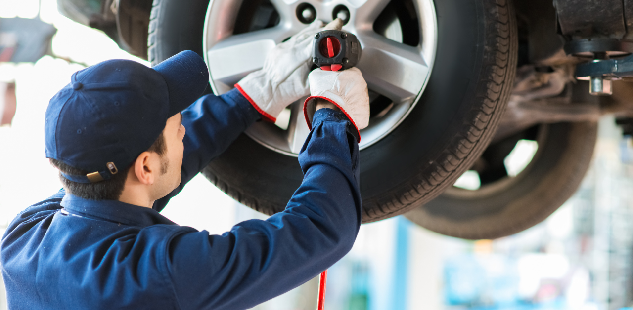 Mechanic repairs car tire in shop, part of the repair process after a car accident claim