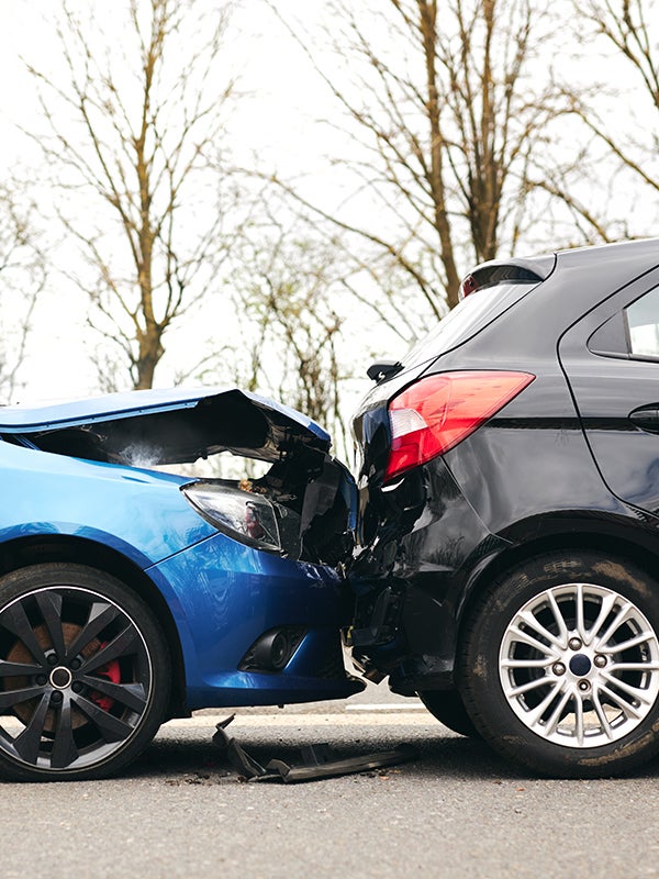 Blue and black cars after a rear-end collision, showing extensive damage to the front of the blue car.